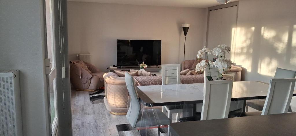 a living room with a table and a couch at Chambre privée dans grand et superbe appartement proche paris in Creil