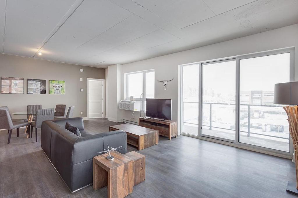 ein Wohnzimmer mit Sofa und Fernseher in der Unterkunft Corporate Stays Equinoxe 3 Bedrooms in Chomedey