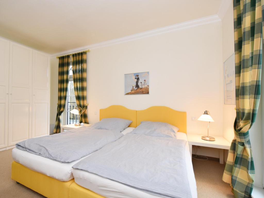 1 dormitorio con 1 cama amarilla, escritorio y 1 cama en Ferienwohnung Parkblick, en Poseritz