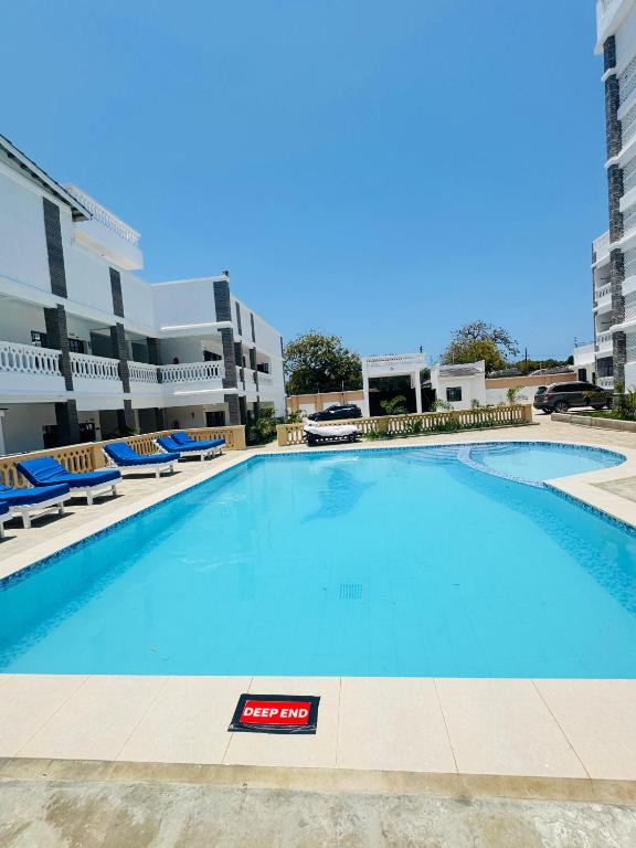 a large swimming pool with blue water in a building at KK Homes in Diani Beach