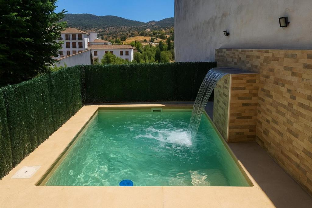 ein Swimmingpool mit Wasserfontäne in der Unterkunft Casa Ignacio a 15 minutos de Ronda in Arriate