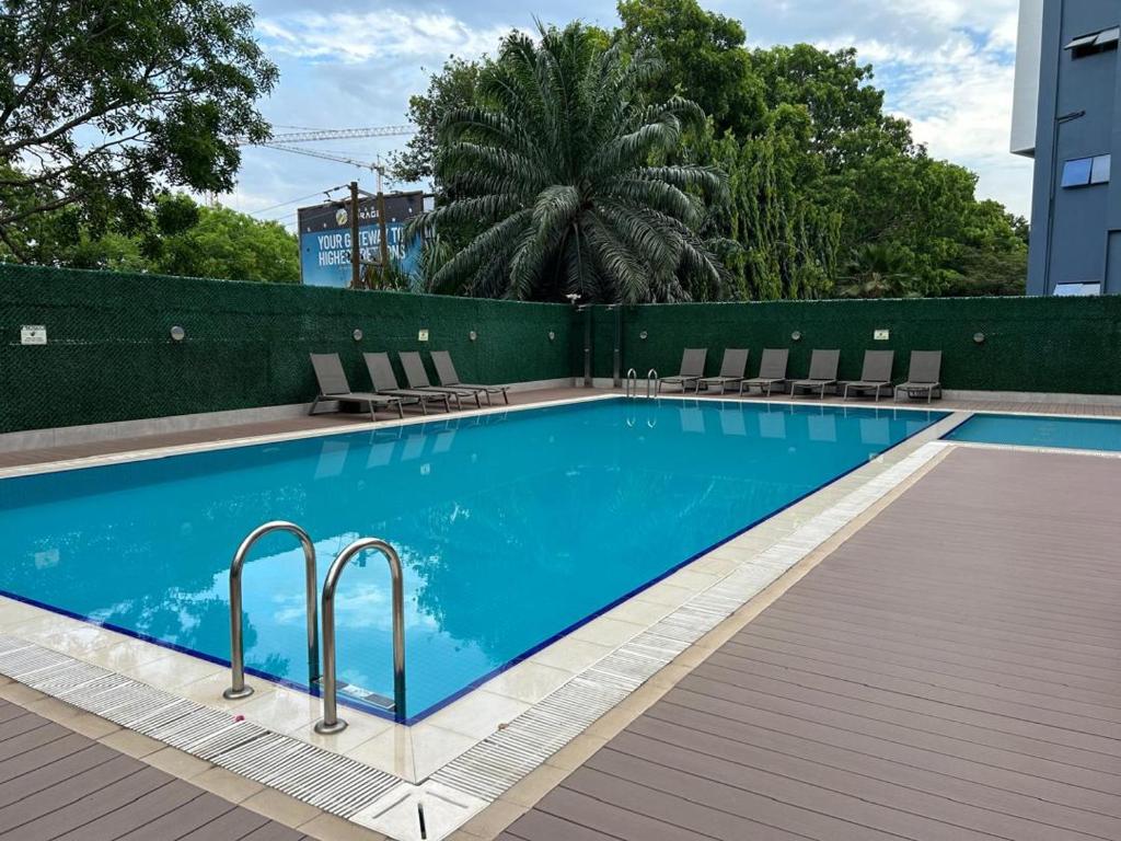 una piscina con sedie accanto a un edificio di Mirage suite a Accra