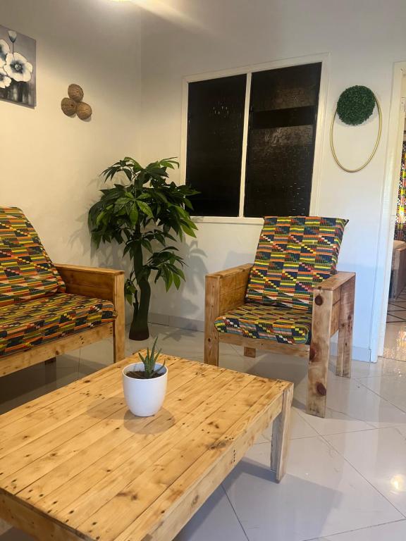 a living room with two chairs and a wooden table at Beach house villa in Kokrobite