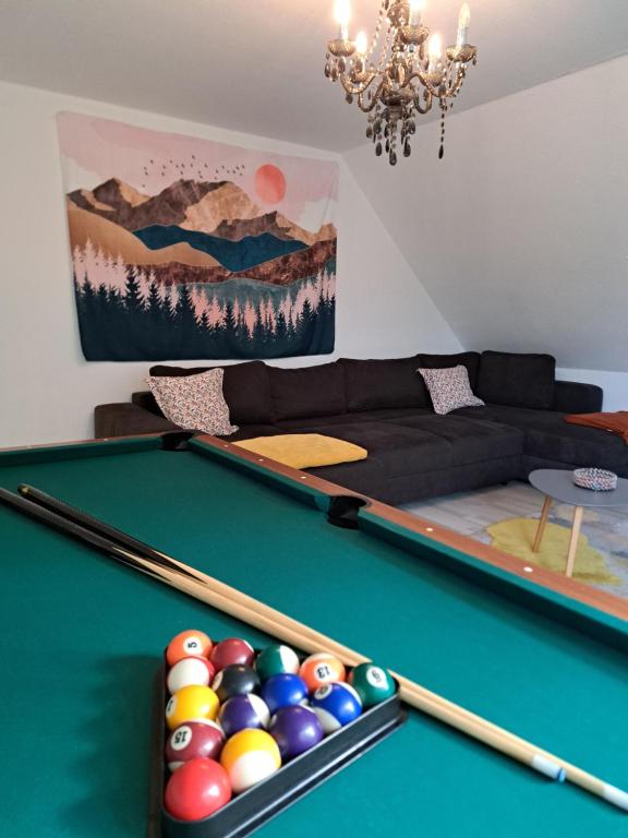 Una sala de estar con una mesa de billar y un sofá. en Familienparadies auf dem Reiterhof, en Bad Nenndorf