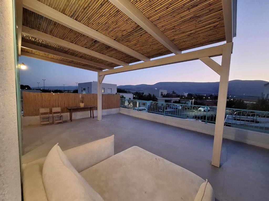 a patio with a couch and a table on a roof at מעיינות האהבה in Reshafim
