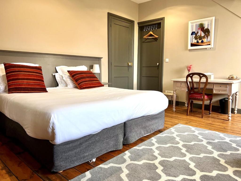 a bedroom with a large bed with red pillows and a desk at T1 lumineux & cosy, vue Cathédrale, Amiens centre in La Celle-sous-Gouzon