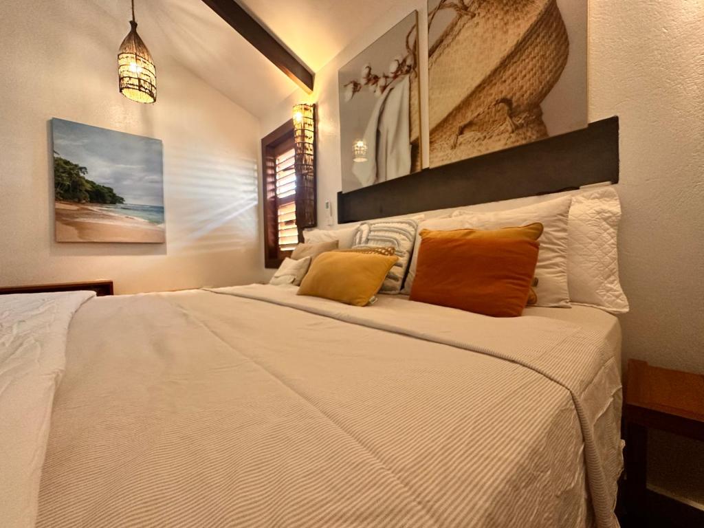 een slaapkamer met een groot wit bed met oranje kussens bij Casa nova in Prea