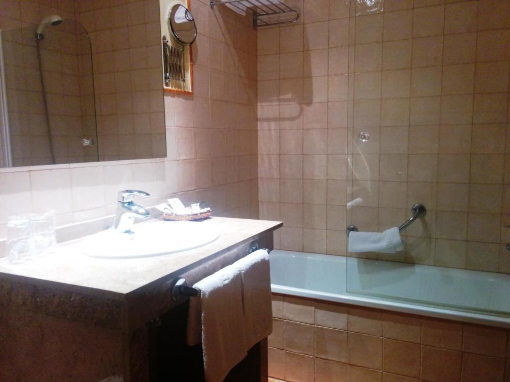 W łazience znajduje się umywalka, wanna i umywalka. w obiekcie Hotel Sierra de Andujar w mieście Virgen de la Cabeza