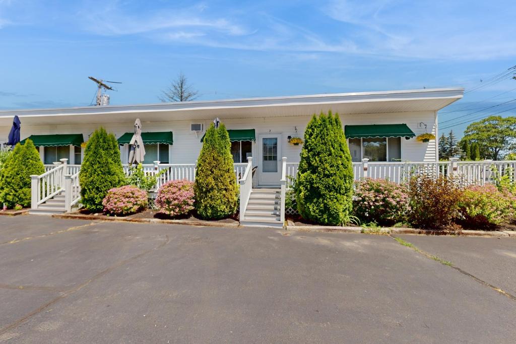 a white house with a white fence and trees at Sparkling Sands Holiday House M2 in Moody