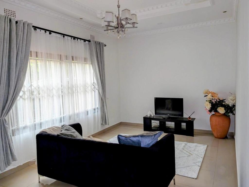 a living room with a couch and a television at The Acacia Apartment in Lusaka