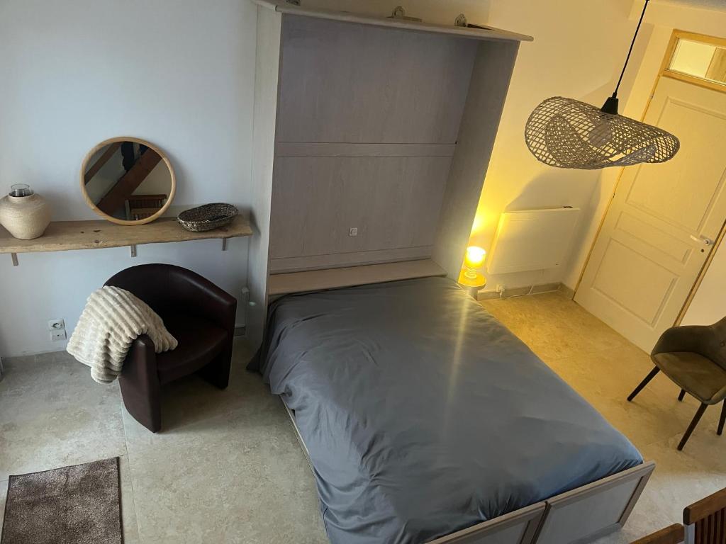 une chambre avec un lit, une chaise et un miroir dans l'établissement Six Duplex à la montagne POMPIERY, à Seyne