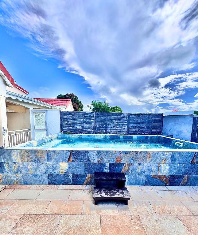a swimming pool in front of a house at Résidence chez Adine in Sainte-Anne