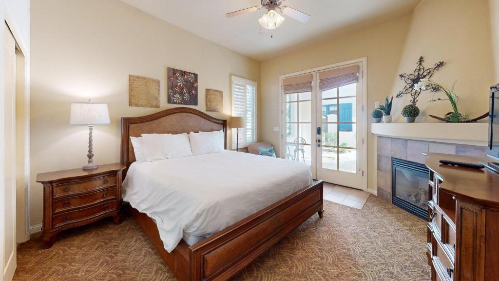 a bedroom with a bed and a dresser and a fireplace at LV026 Secluded Downstairs Legacy Villas Studio in La Quinta