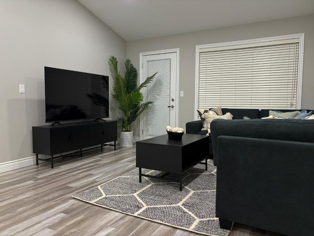 a living room with a couch and a flat screen tv at Modern Private Suite close to the Airport & Border in Windsor