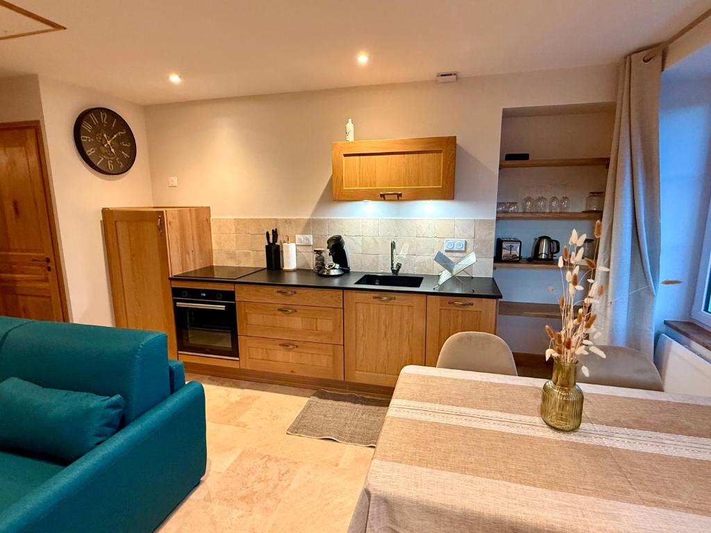a kitchen with a blue couch and a counter top at Gîte du Pavillon 4 pers Wi-Fi Haute Marne in Arc-en-Barrois