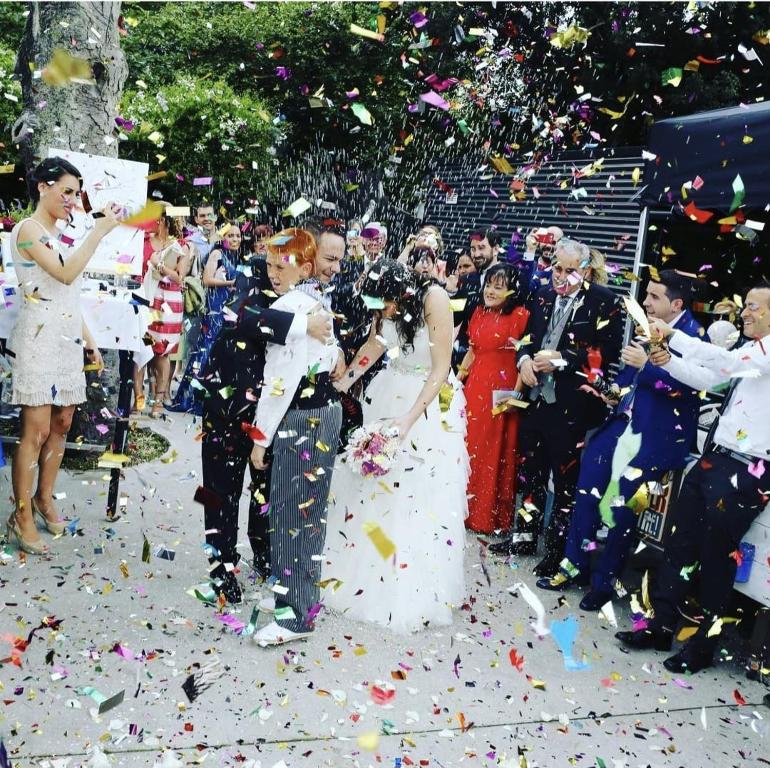 a bride and groom are standing in confetti at Hotel Olajauregi in Durango