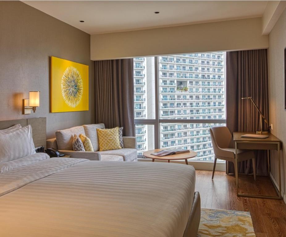 a hotel room with a bed and a large window at Novotel Executive Suite - Acqua Manila in Manila