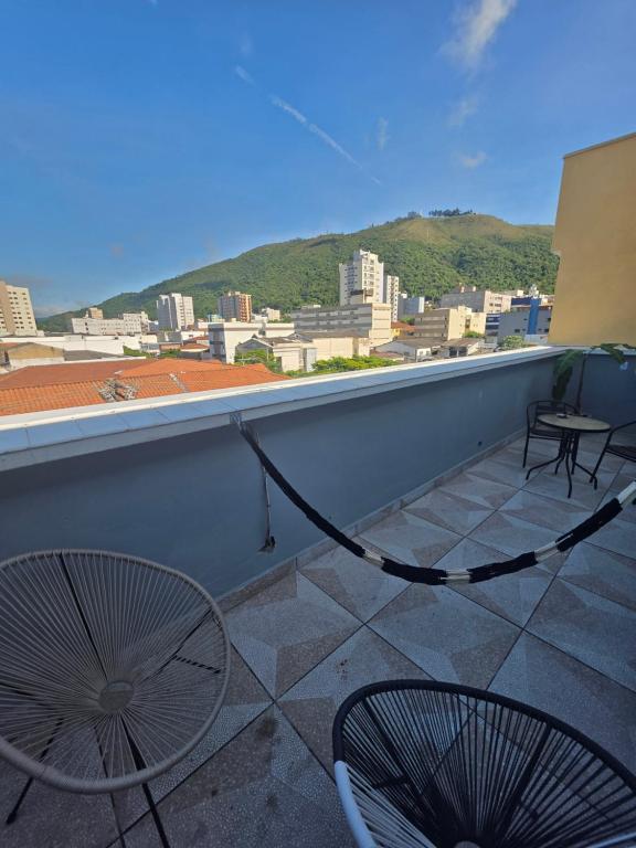 a balcony with two chairs and a view of a city at APTO 401 - no centro, pertinho de tudo in Poços de Caldas