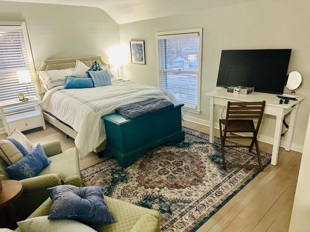 ein Schlafzimmer mit einem Bett, einem Schreibtisch und einem Fernseher in der Unterkunft The Birchwood - At Twin Pines-Walk to the Lake! in Clear Lake