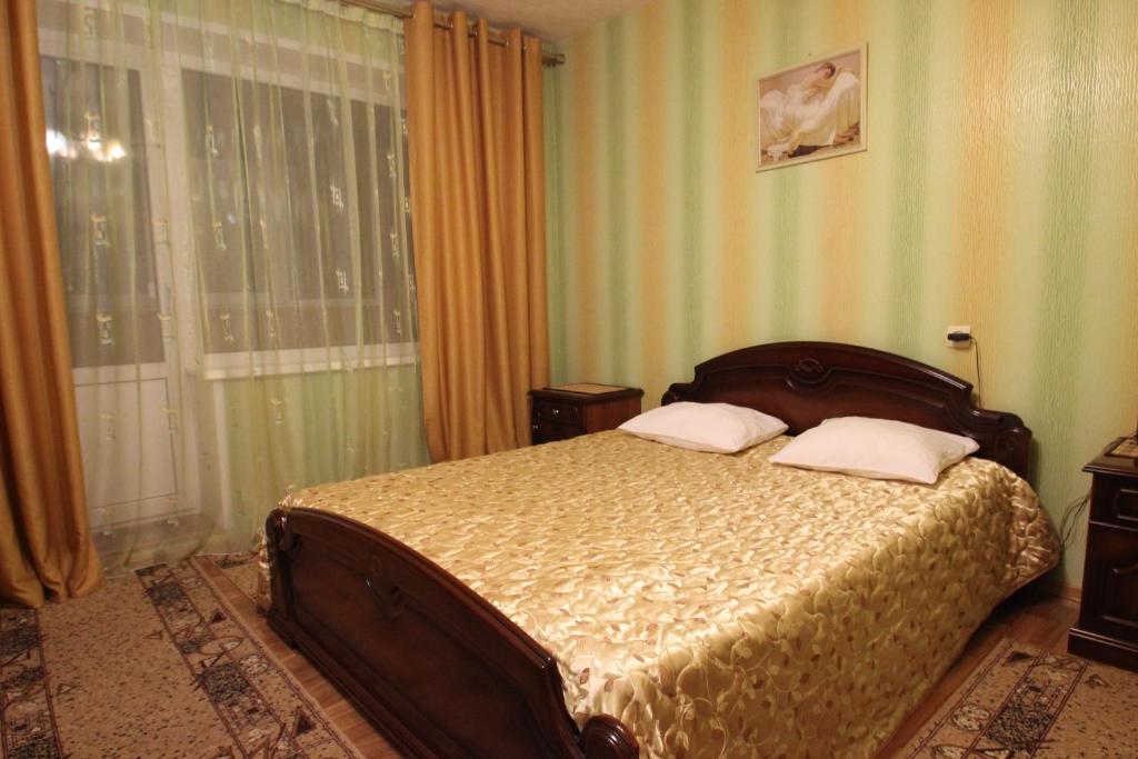 een slaapkamer met een bed met 2 kussens erop bij Apartment Srednemoskovskaya in Voronezj