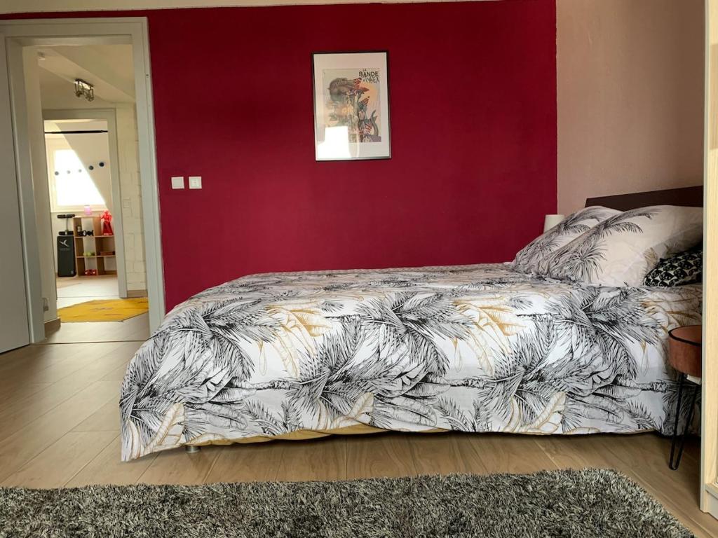 a bedroom with a large bed in a red wall at Appartement dans charmante maison près de Sarrebruck in Grosbliederstroff