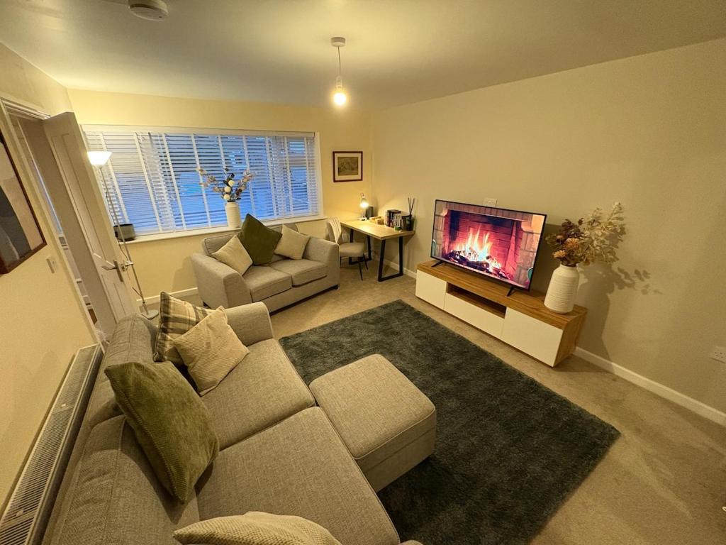 ein Wohnzimmer mit Couch und Flachbildfernseher in der Unterkunft Greenfield House - Keighley Eastburn in Kildwick