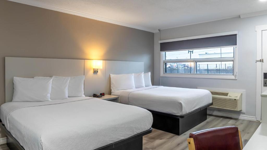 a hotel room with two beds and a window at Motel 6 Cornwall Hwy 401 ON in Cornwall
