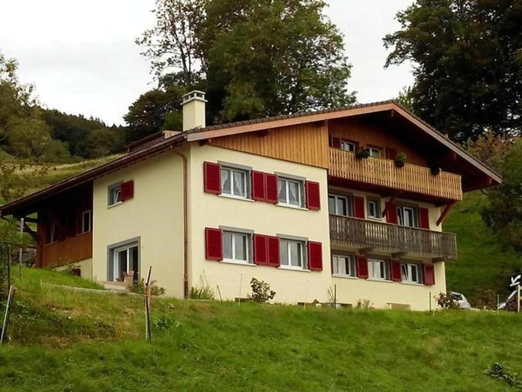 a large house with red shutters on a hill at Studio In Renoviertes Bauernhaus 3 Pers in Chardonne