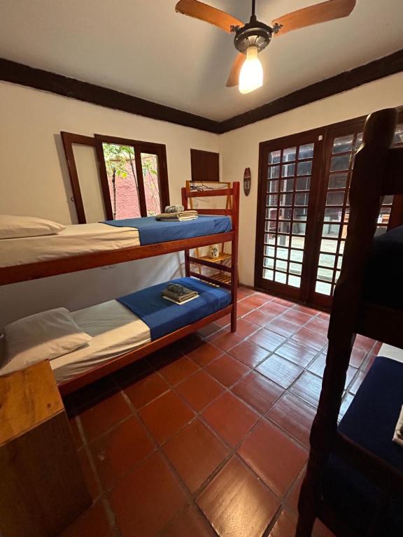 a bedroom with two bunk beds and a ceiling fan at Numa Boa HOSTEL Búzios in Búzios