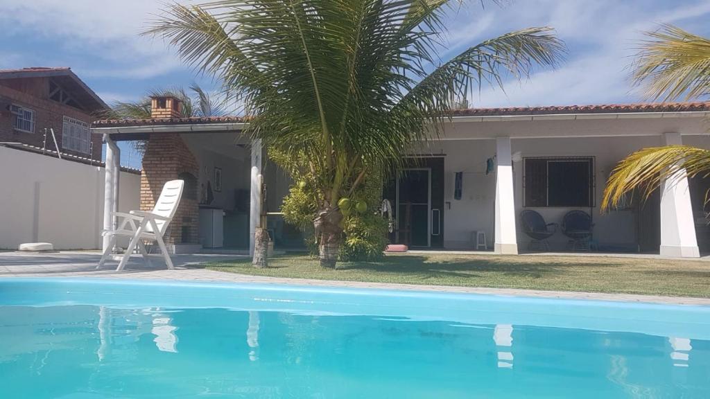 ein Haus mit einer Palme und einem Pool in der Unterkunft Casa no cumbuco in Caucaia