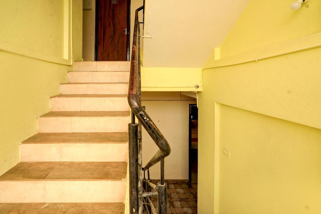 un escalier dans un bâtiment avec une rampe métallique dans l'établissement Hotel O Thanisandra Railway Station Formerly Urban Drift, à Yelahanka