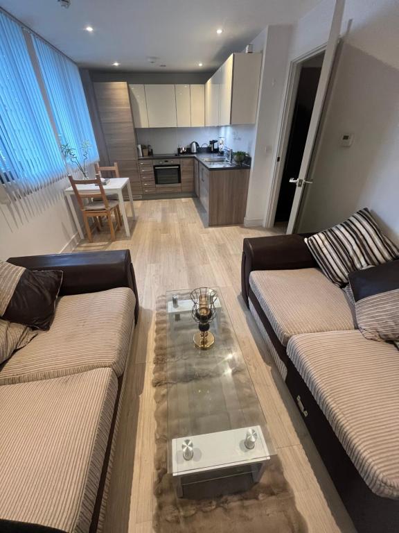 a living room with two couches and a coffee table at Your Private Apartment in Vibrant Wembley! in London