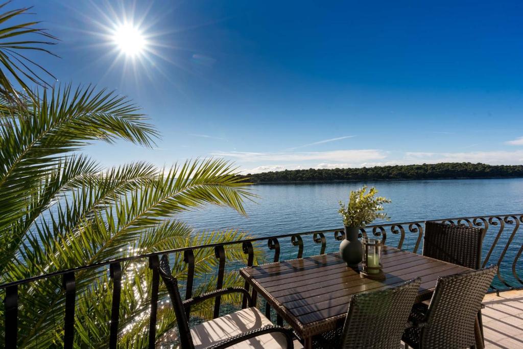 a table on a balcony with a view of the water at Apartment Julietta in Rab