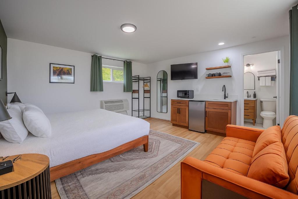 a bedroom with a bed and a couch and a kitchen at The Inn at Shady Pines in Gros Cap