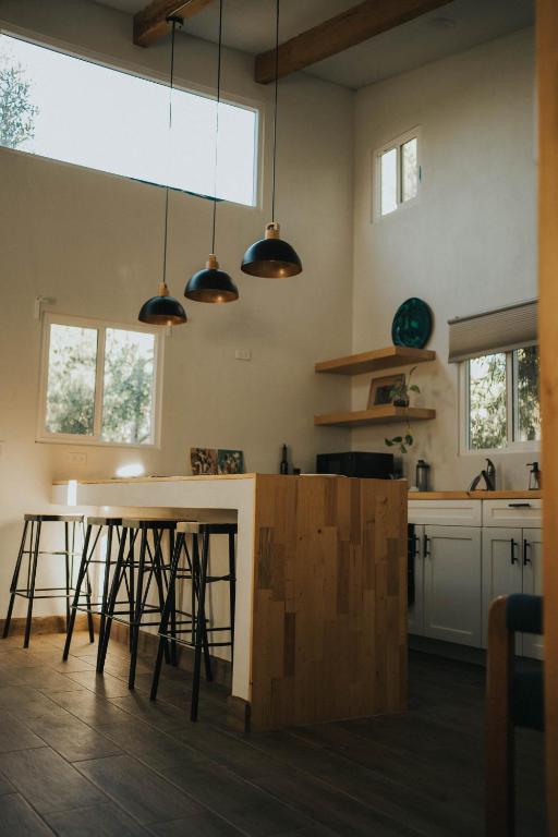 a kitchen with a table and some stools at La Mata de Nuez in Valle de Guadalupe