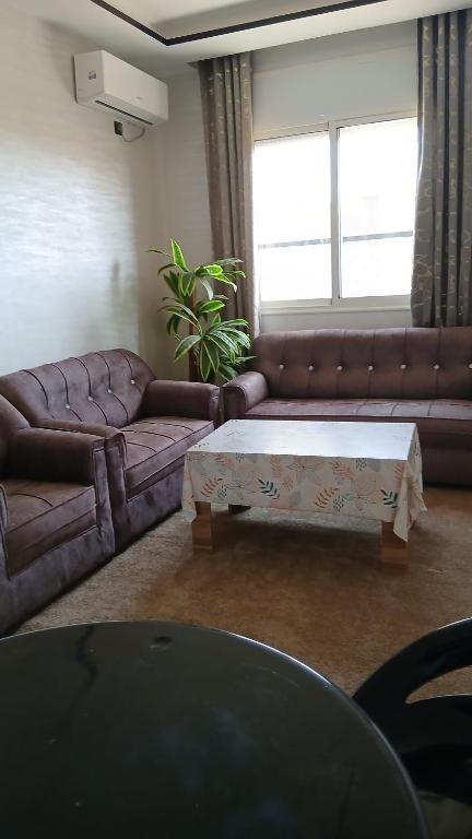 Una sala de estar con un sofá y una mesa de café. en Appartement, en Chichaoua