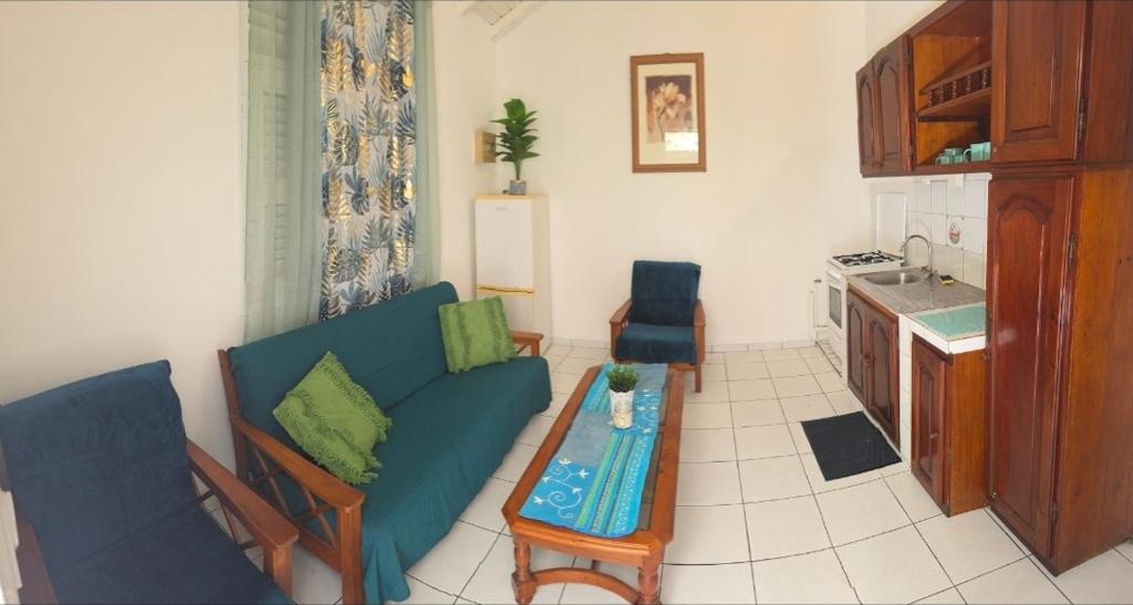 a living room with a couch and a table at Résidence Fleur de Café in Lamentin