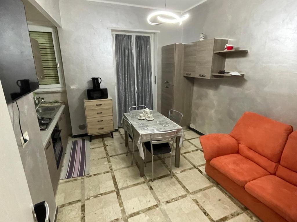 Una sala de estar con un sofá naranja y una mesa. en Casa di Dome, en Turín