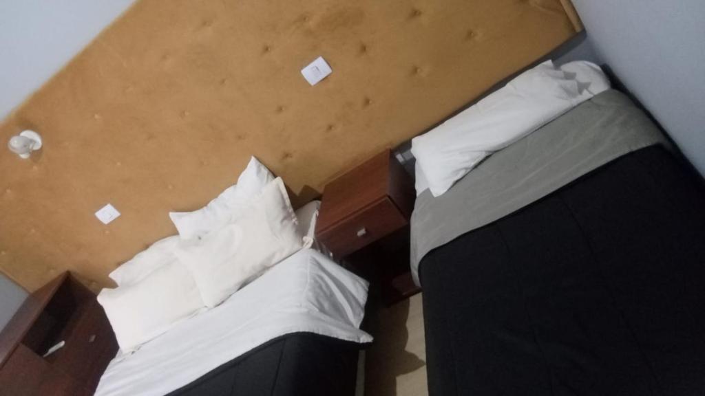 two beds in a room with a box at HOTEL RESTAURANTE Ruta 66 in Paso de los Libres