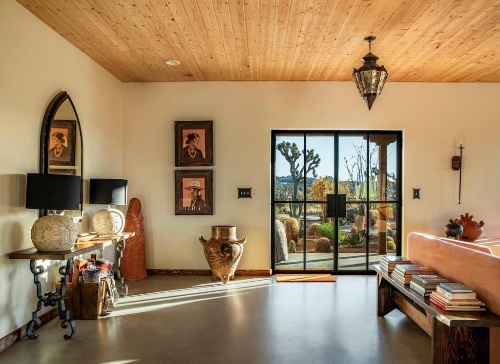 a living room with a couch and a large glass door at Salt Pool - Sauna - Cold Plunge - Lux Desert Ranch in Pioneertown