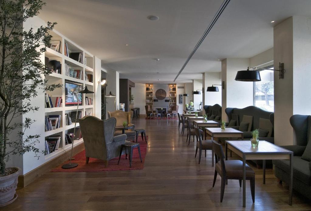 a waiting room with tables and chairs in a building at Starhotels Tuscany in Florence