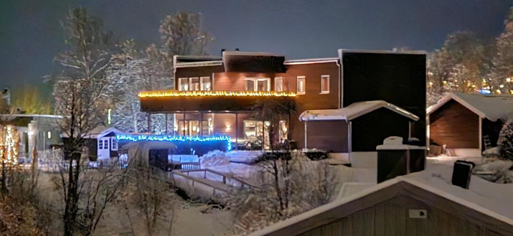 een huis in de sneeuw 's nachts met lichten bij LØVEHAUGEn in Trondalen