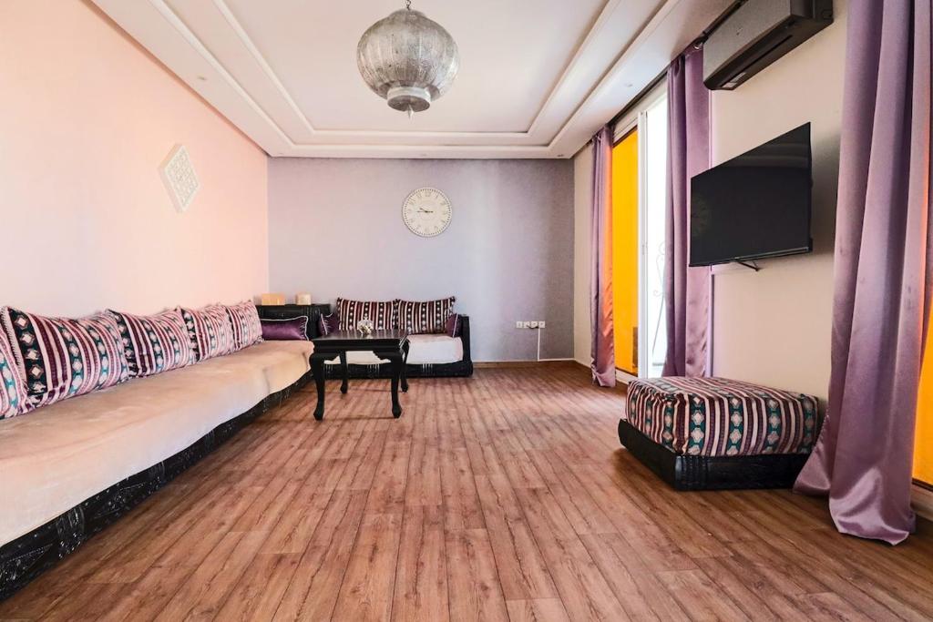 a living room with a couch and a table at L'Andalou -3 bedrooms with Parking in Downtown in Kenitra