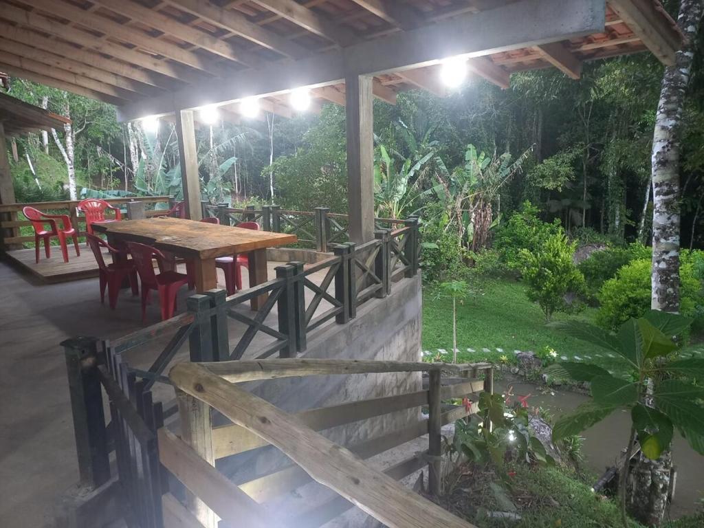 a patio with a wooden table and chairs on a porch at Sitio Daniela in São João Batista