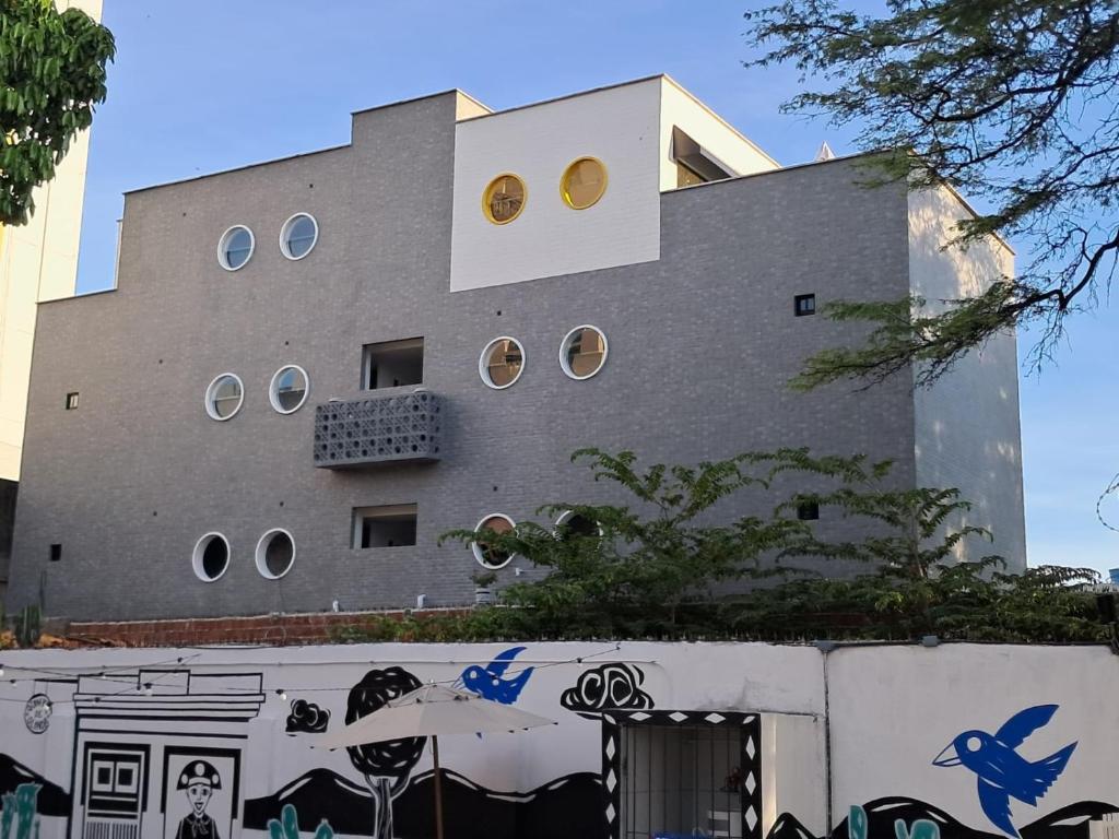 a building with round windows on the side of it at Carambola CoLiving in Olinda