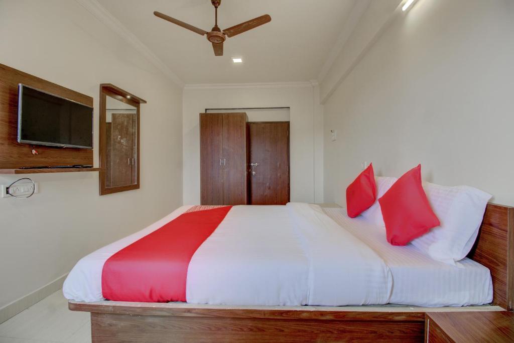 a bedroom with a large bed with red pillows at Hotel O Della Comforts in Ambernath