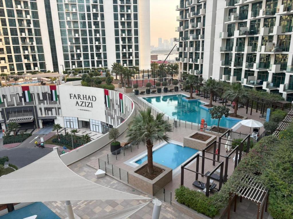 een luchtzicht op een resort met 2 zwembaden en gebouwen bij Deluxe studio water front in Dubai