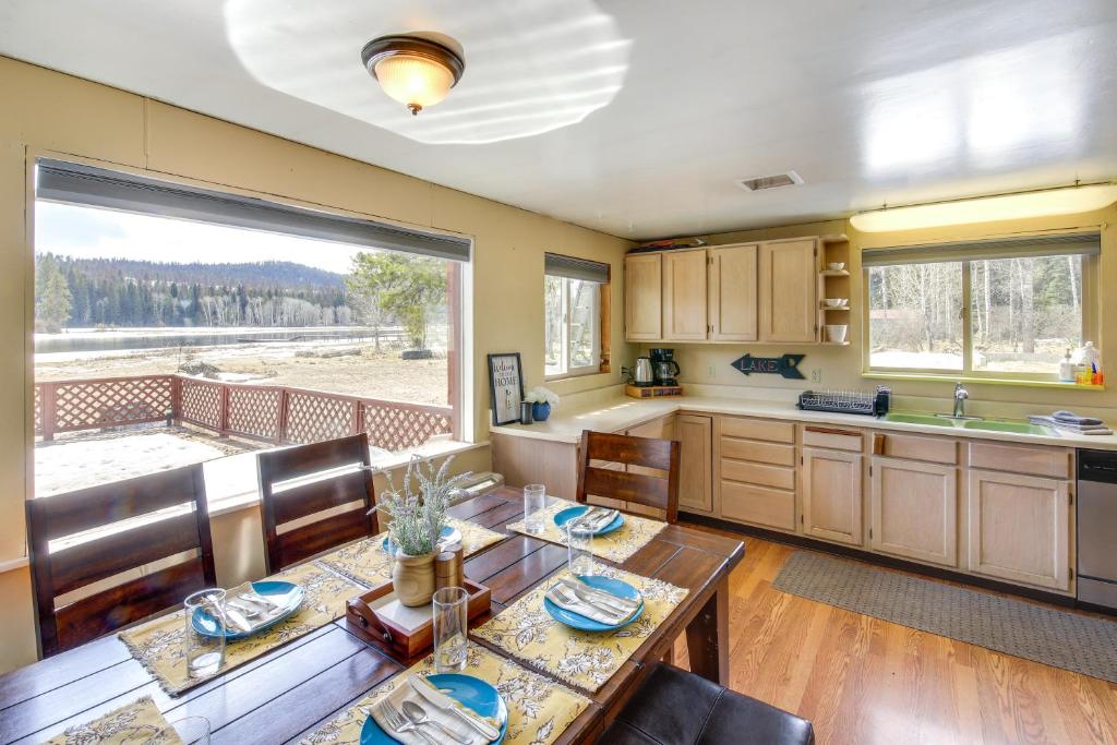 een keuken met een eettafel en een groot raam bij Hike, Bike and Boat Cabin with Dock on Seeley Lake! in Seeley Lake