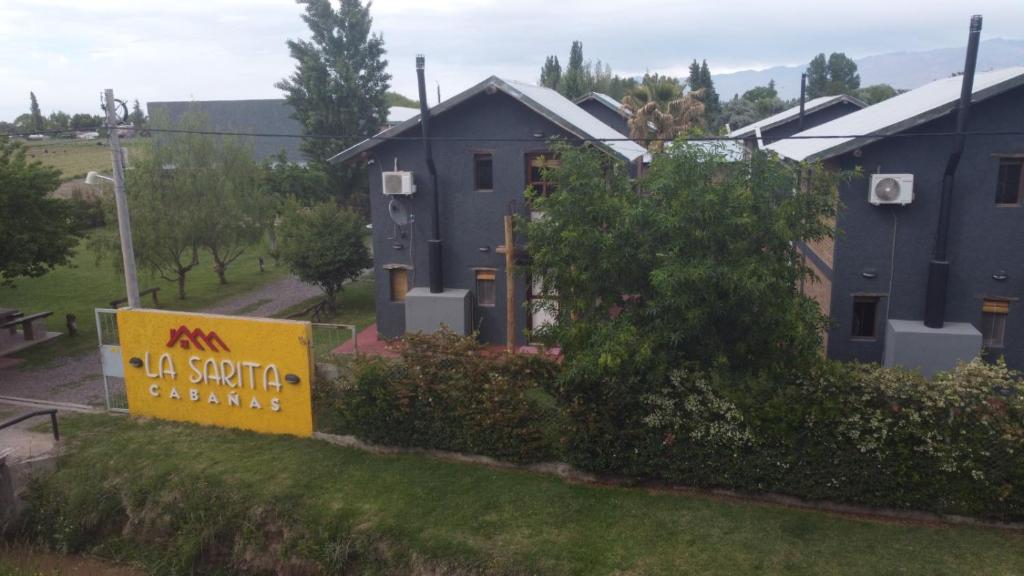 a house with a sign in front of it at Cabañas La Sarita in La Consulta