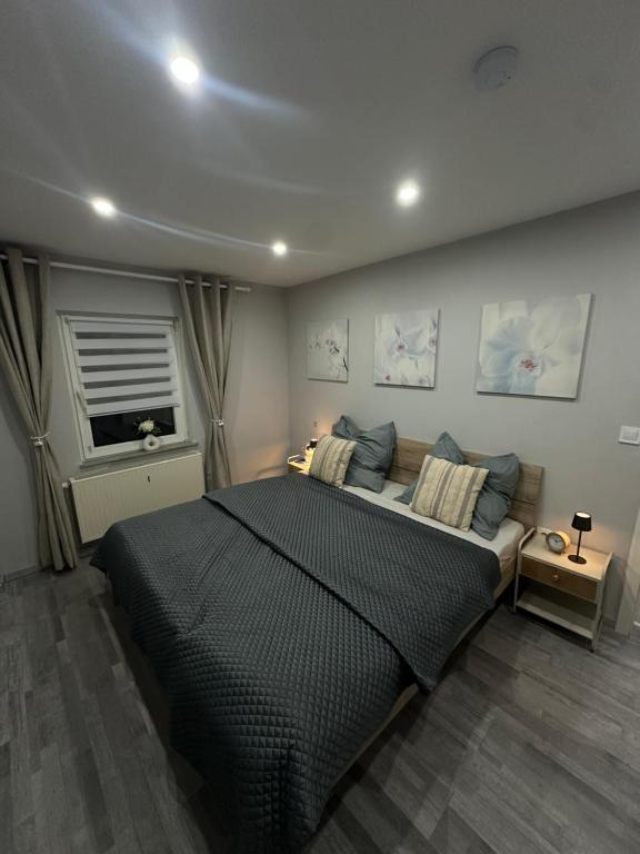 een slaapkamer met een groot zwart bed en een raam bij Stylish Home Theater Apartment 3 in Kreuztal